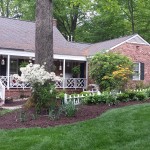 Green lawn in front of B&B with trees and bushes
