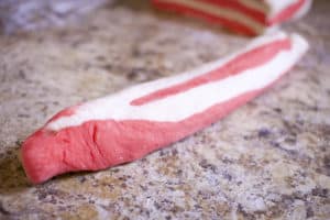 cut red and white bagel dough rolled into a long strip
